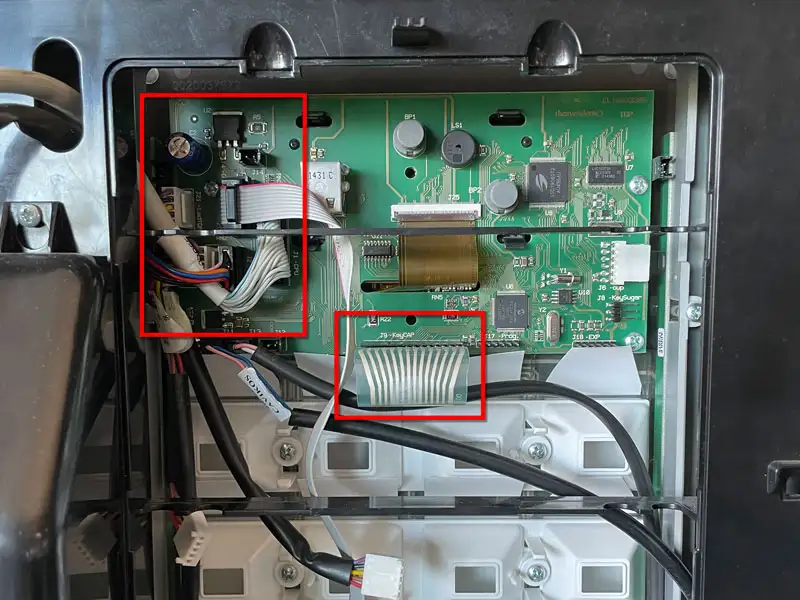 Geoeffnete Rueckwand eines Kaffeevollautomaten mit sichtbaren Platinen und Kabelverbindungen.