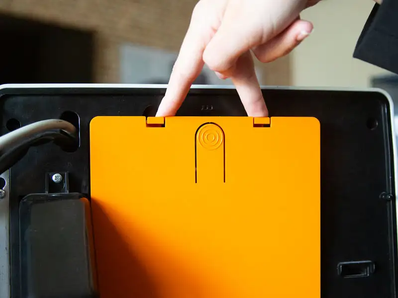 Servicetuer der Kaffeemaschine geoeffnet, orangefarbene Innenplatte sichtbar.