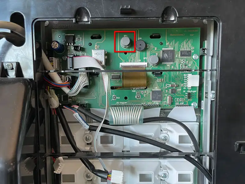 Geoeffnete Maschine mit sichtbarer Steuerplatine und markierten Anschluessen.