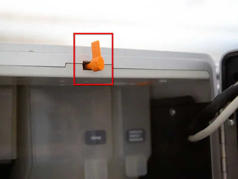 Nahaufnahme eines orangefarbenen Programmierschluessels im oberen Bereich der Kaffeemaschine.