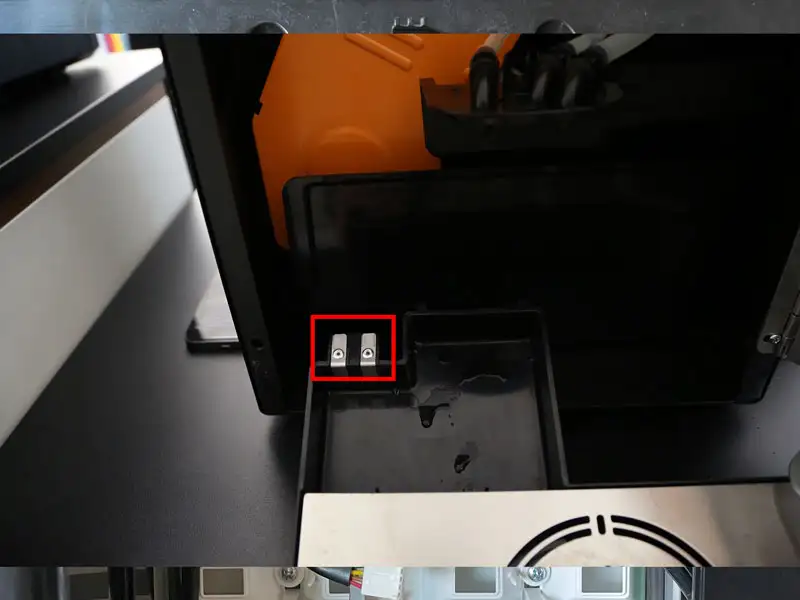 Geoeffnete Tropfschale einer Kaffeemaschine mit markierten Kontakten fuer Fuellstandssensoren.