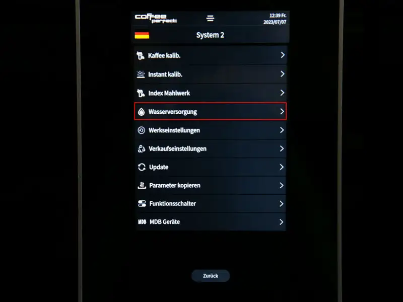Display eines Kaffeevollautomaten mit markierter Option 'Wasserversorgung' im Menue System 2.