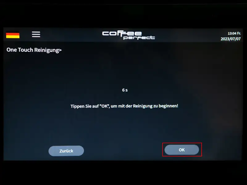 Display zeigt Reinigungsbildschirm mit 'OK'-Button zum Start der One Touch Reinigung.