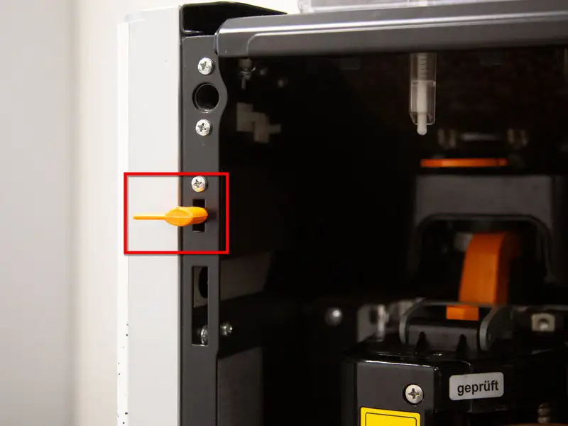 Seitliche Ansicht eines eingesetzten orangefarbenen Programmierschluessels an der Kaffeemaschine.