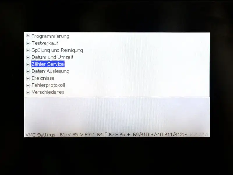 Display zeigt Menue mit Schraubenschluessel-Symbol und Anzeige '1=Programmierung 2=Zaehler alle'.